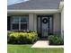 Close up of a front door with glass insets, a wreath, and green shrubbery at 6686 Treymont Dr, Lakeland, FL 33813
