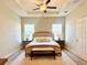 Serene main bedroom with a tray ceiling, neutral tones, and a cozy seating bench at 6686 Treymont Dr, Lakeland, FL 33813