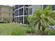 Landscaped condominium building with large grassy common area and tropical foliage at 717 S Beach St # 205C, Daytona Beach, FL 32114