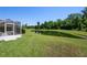 Backyard view featuring a pond, grassy area, and screened-in porch at 7233 Mystic Brook Way, Davenport, FL 33896