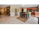 Cozy dining area featuring wood-look accent wall, table, and open-concept kitchen with stainless steel appliances at 7233 Mystic Brook Way, Davenport, FL 33896