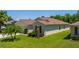 Well-maintained home with lush green lawn, mature landscaping, and a glimpse of the side entrance at 7233 Mystic Brook Way, Davenport, FL 33896