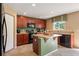 Well-equipped kitchen with wooden cabinets, an island, modern appliances, and a view of the backyard at 7233 Mystic Brook Way, Davenport, FL 33896