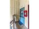 Cozy condo entrance with a teal door, welcome mat, and fire extinguisher, adding a touch of home at 758 E Michigan St # 208, Orlando, FL 32806