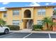 Inviting yellow condo building with well-kept landscaping and convenient parking at 758 E Michigan St # 208, Orlando, FL 32806