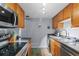 Functional kitchen featuring stainless appliances, wood cabinets, and laundry at 758 E Michigan St # 208, Orlando, FL 32806