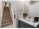 Well-lit half bathroom with modern vanity and fixtures, conveniently located near the staircase at 772 Driving Range Ct, Kissimmee, FL 34747