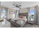 Bright bedroom featuring a ceiling fan, large windows, gray headboard, and modern dresser at 772 Driving Range Ct, Kissimmee, FL 34747