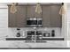 Close-up of modern kitchen featuring stainless steel appliances and gray cabinets at 772 Driving Range Ct, Kissimmee, FL 34747