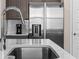 Close-up of kitchen island sink with stainless steel appliances and gray cabinets at 772 Driving Range Ct, Kissimmee, FL 34747