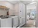Convenient laundry room features washer, dryer, shelving, and view into the bedroom at 772 Driving Range Ct, Kissimmee, FL 34747