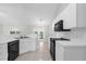 Well-lit kitchen featuring white cabinetry, black appliances and tile flooring at 778 Del Prado Dr, Kissimmee, FL 34758