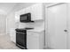 Well-lit kitchen featuring white cabinetry, black appliances and tile flooring at 778 Del Prado Dr, Kissimmee, FL 34758