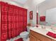 Charming bathroom with a bright red color theme, featuring a well-lit vanity and essential amenities at 8333 Via Verona, Orlando, FL 32836