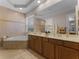 Luxurious bathroom with double sinks, a soaking tub, and elegant tile work, perfect for relaxation at 8333 Via Verona, Orlando, FL 32836
