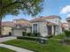 Beautiful home featuring a manicured lawn, red front door, brick driveway, and a two-car garage at 8333 Via Verona, Orlando, FL 32836