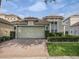 Home featuring a brick driveway, two-car garage, manicured lawn, and a well-maintained exterior at 8333 Via Verona, Orlando, FL 32836