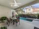 Covered patio with a ceiling fan overlooking the pool and a table setting for enjoying outdoor meals at 8333 Via Verona, Orlando, FL 32836