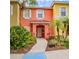 Brightly painted townhome with well-manicured landscaping and a clear, inviting walkway leading to the front door at 8502 Crystal Cove Loop, Kissimmee, FL 34747