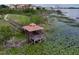 Aerial shot of a gazebo on a lake with lily pads, surrounded by green spaces and waterfront properties at 8515 Saint Marino Blvd, Orlando, FL 32836