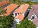 Aerial view of a home with a terra cotta roof, well-maintained landscaping, and a peaceful neighborhood at 8515 Saint Marino Blvd, Orlando, FL 32836