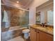 Bathroom featuring a shower-over-tub with glass doors, granite countertop, and single sink vanity at 8515 Saint Marino Blvd, Orlando, FL 32836