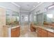 An opulent bathroom with a soaking tub nestled between two vanities and beneath a bright window at 8515 Saint Marino Blvd, Orlando, FL 32836