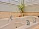 Close up of soaking tub with tile surround and chrome fixtures, complemented by elegant decor at 8515 Saint Marino Blvd, Orlando, FL 32836