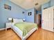 Bright bedroom featuring hardwood floors, a ceiling fan, and large windows overlooking a lake at 8515 Saint Marino Blvd, Orlando, FL 32836