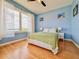 Bright bedroom featuring hardwood floors, a ceiling fan, and large windows overlooking a lake at 8515 Saint Marino Blvd, Orlando, FL 32836
