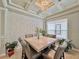 Stylish dining area with a marble table, elegant seating, a decorative wall, and a contemporary chandelier at 8515 Saint Marino Blvd, Orlando, FL 32836