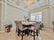 Elegant dining room featuring a marble table, studded chairs, textured accent wall, and a modern chandelier at 8515 Saint Marino Blvd, Orlando, FL 32836
