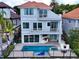 Aerial shot of a gray two-story home with a red tile roof, pool, outdoor kitchen, and balcony at 8515 Saint Marino Blvd, Orlando, FL 32836