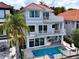Exterior view of a gray, multi-story home with a pool, spa, and an outdoor kitchen at 8515 Saint Marino Blvd, Orlando, FL 32836