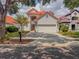 Charming two-story home featuring a red tile roof, a brick driveway and lush landscaping at 8515 Saint Marino Blvd, Orlando, FL 32836