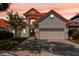 Charming two-story home featuring a red tile roof, a brick driveway and lush landscaping at 8515 Saint Marino Blvd, Orlando, FL 32836