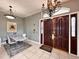 Inviting foyer with elegant chandelier, stylish tile flooring, and an impressive dark wood entry door at 8515 Saint Marino Blvd, Orlando, FL 32836
