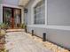 Front door with a tiled walkway and landscape lighting at 8515 Saint Marino Blvd, Orlando, FL 32836