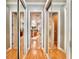 Hallway with mirrored closet doors leading to bathroom with double sinks and a soaking tub at 8515 Saint Marino Blvd, Orlando, FL 32836