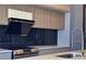 Contemporary kitchen with stainless steel appliances and a sleek cooktop under a modern hood at 8515 Saint Marino Blvd, Orlando, FL 32836