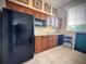 Features a modern kitchen, wood cabinets, tile floor, and black appliances including a refrigerator and microwave at 8515 Saint Marino Blvd, Orlando, FL 32836