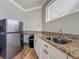 View of the kitchenette with stainless fridge, granite counters, and white cabinets at 8515 Saint Marino Blvd, Orlando, FL 32836