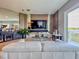 Living room with elegant furniture, a modern entertainment center, and a scenic view from the sliding glass doors at 8515 Saint Marino Blvd, Orlando, FL 32836