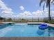 Inviting pool with blue water and a glimpse of the lake beyond the black metal fence at 8515 Saint Marino Blvd, Orlando, FL 32836