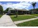 Beautiful one-story home with landscaped front yard, green lawn, and driveway at 8613 Edge O Woods Ct, Orlando, FL 32819