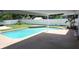 Backyard pool area with covered patio, surrounded by a privacy fence and green space at 8613 Edge O Woods Ct, Orlando, FL 32819