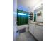 Bathroom features a bathtub with a translucent green shower curtain, a toilet, and a vanity with double sinks at 9208 Chandler Dr, Groveland, FL 34736