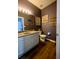 The stylish bathroom features a modern vanity, toilet, and unique wall decor at 9208 Chandler Dr, Groveland, FL 34736