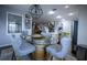 A dining room features a barrel table, soft chairs, and an open floor plan to the kitchen at 9208 Chandler Dr, Groveland, FL 34736
