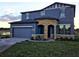 Charming two-story home features a stone-accented entry, attached garage, and well-maintained landscaping at 9208 Chandler Dr, Groveland, FL 34736